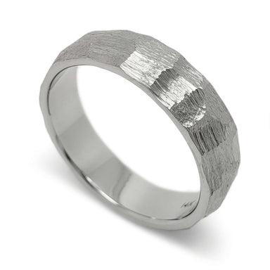 Hand carved 14kt white gold wedding ring with rugged faceted texture, studio view