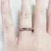 Hand engraved 14k white gold wedding ring with millgrain, worn on a finger