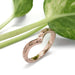 Hand engraved 14kt rose gold chevron ring beside green leaves