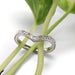 Hand engraved 14kt white gold chevron wedding ring displayed on green plant stems