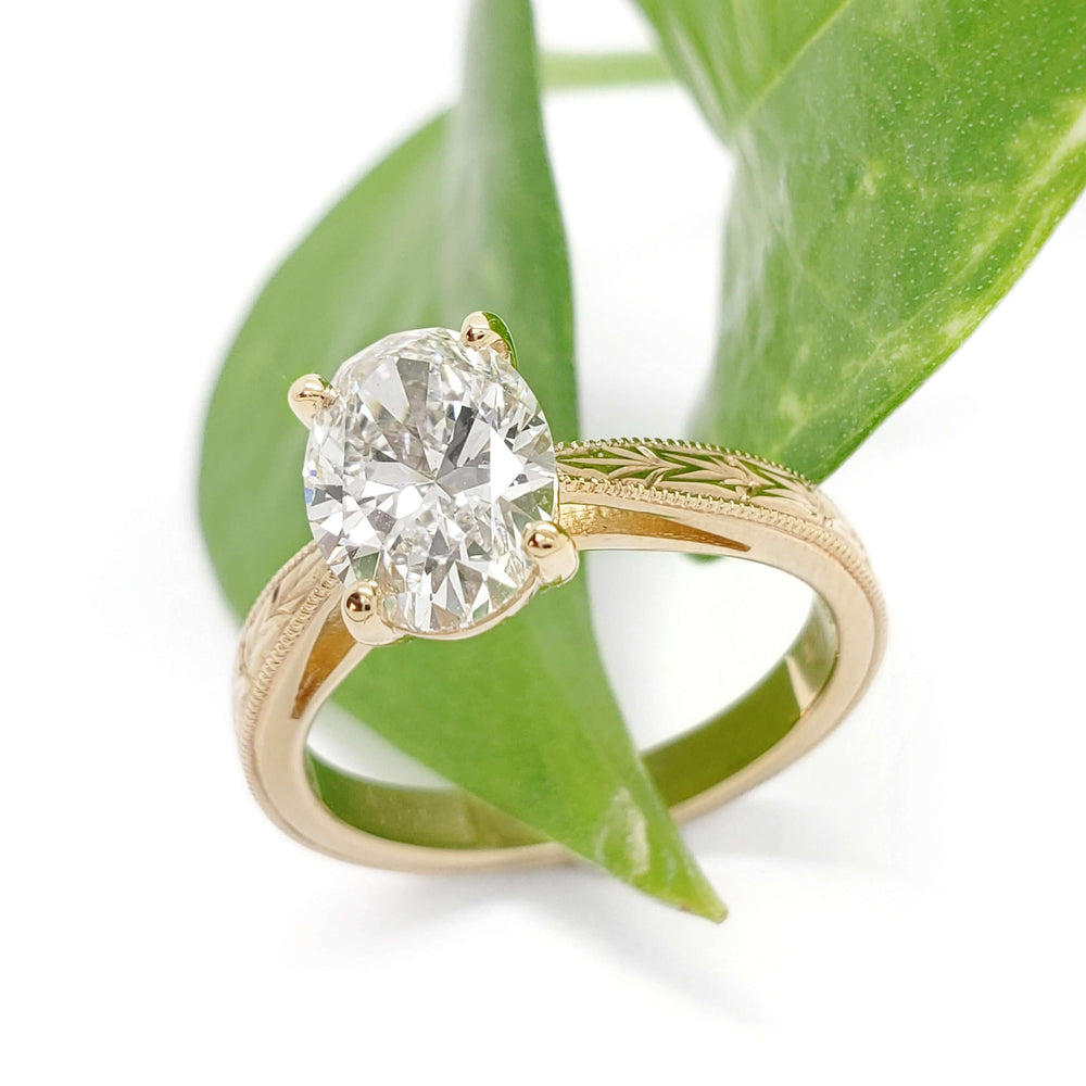 Hand engraved 14kt yellow gold lab diamond ring styled with green leaf