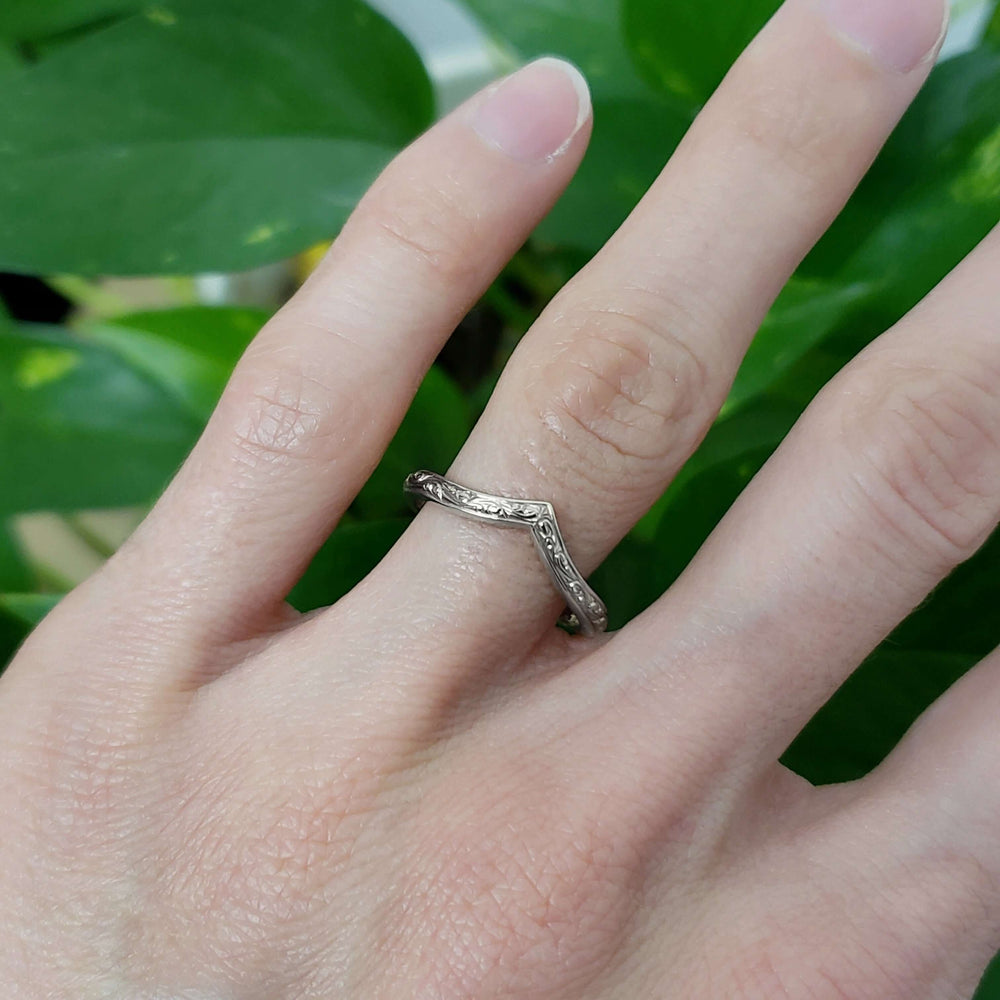 Hand engraved white gold chevron wedding ring worn on finger
