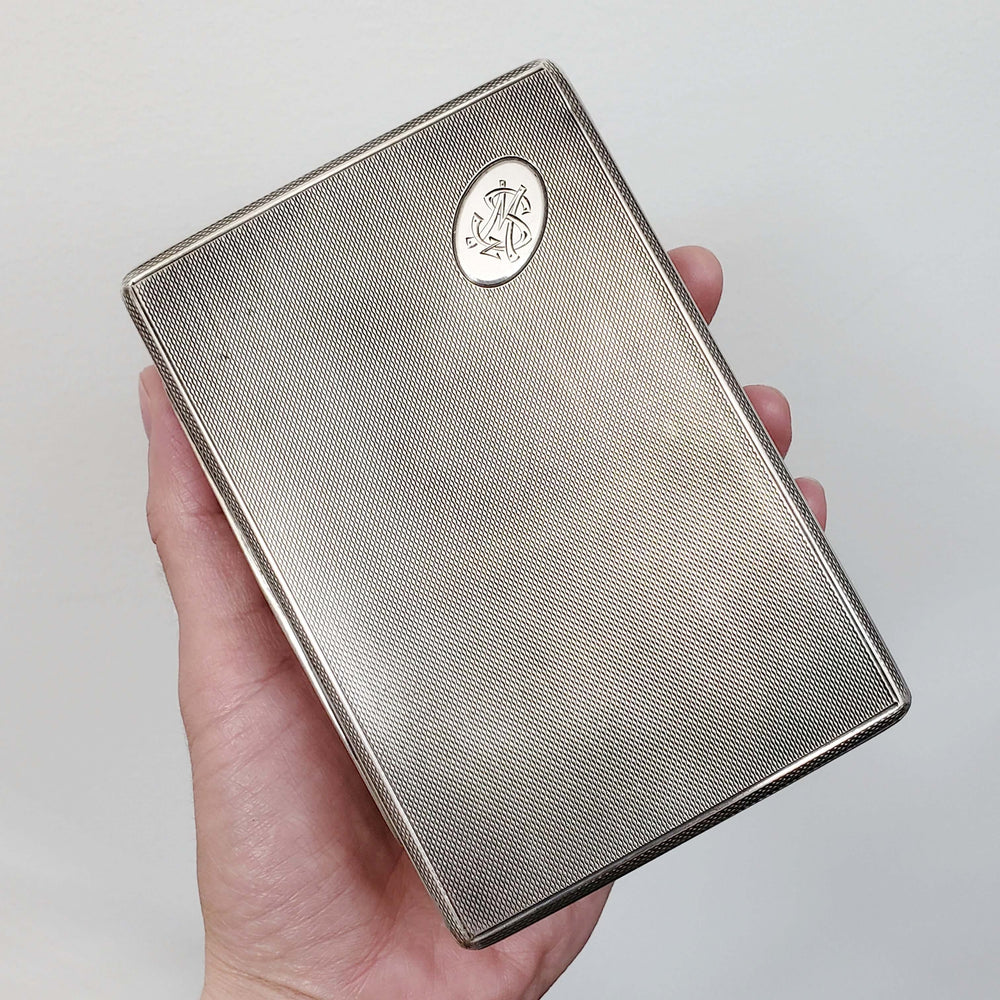 Hand holding vintage silver cigar box showing scale and textured finish