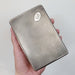 Hand holding vintage silver cigar box showing scale and textured finish
