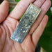 Vintage engraved silver money clip with floral design shown in hand for scale