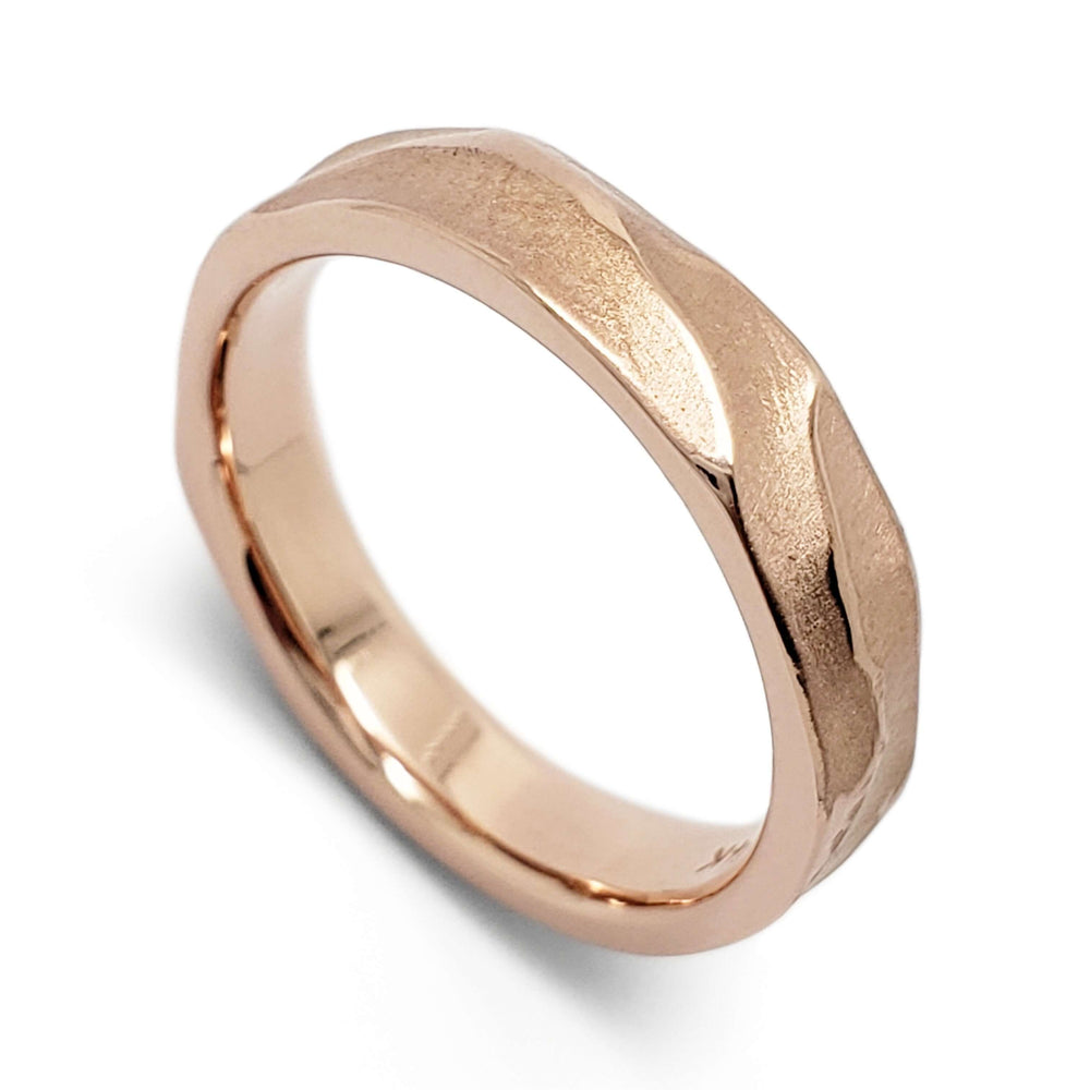 Handcarved 14kt rose gold wedding ring with topography texture on white background