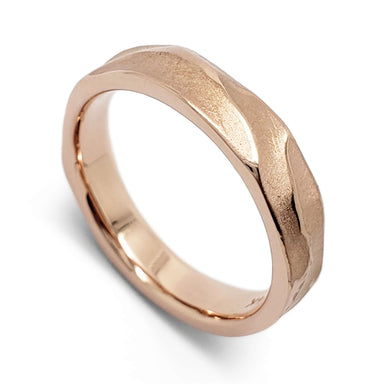 Handcarved 14kt rose gold wedding ring with topography texture on white background