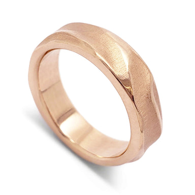 Handcarved 14kt rose gold wedding ring with topography texture, angled view