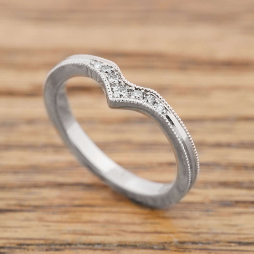 Handcrafted 14k white gold chevron ring with pave Canadian diamonds on wood background