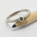 Handcrafted 14k white gold ring with blue sapphire, millgrain detail, beside pencil