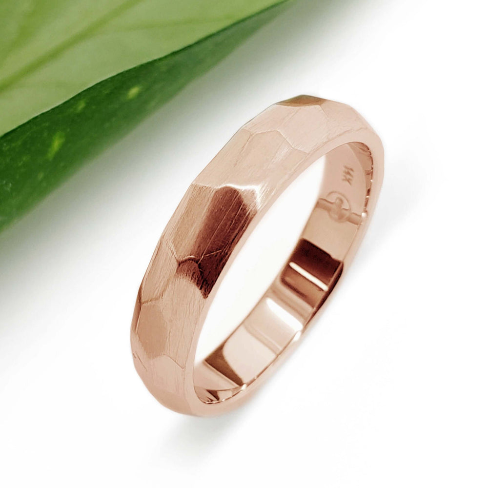 Handcrafted 14kt rose gold faceted wedding band on white background