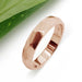 Handcrafted 14kt rose gold faceted wedding band on white background