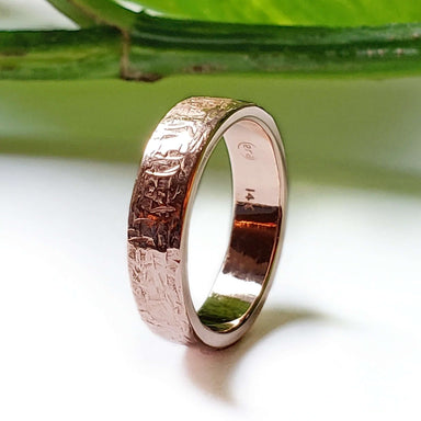 Handcrafted 14kt rose gold wedding ring with elephant skin texture, displayed upright