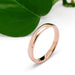 Handcrafted 14kt rose gold wedding ring with low dome profile, near green leaf