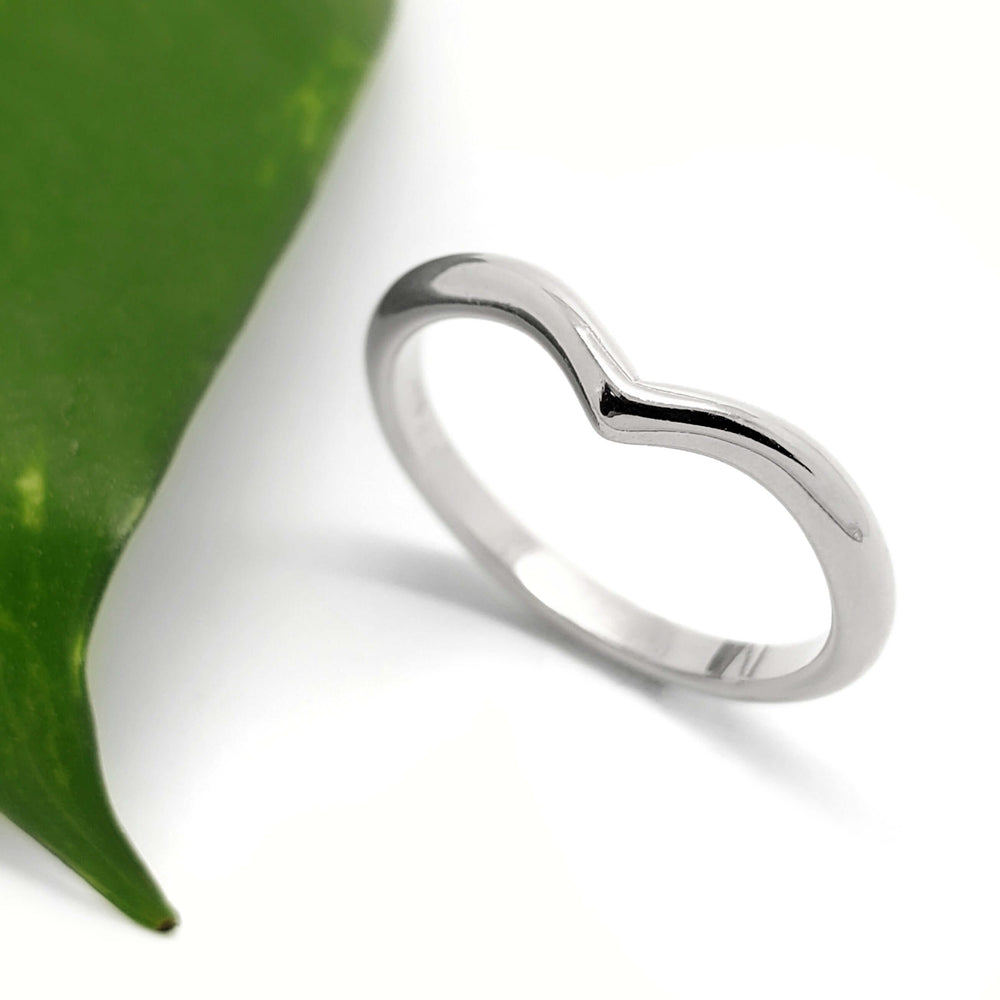 Handcrafted 14kt white gold chevron wedding band on white background with leaf