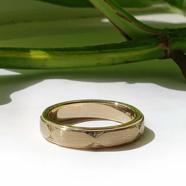 Handcrafted 14kt yellow gold wedding band with engraved Art Deco details in natural light