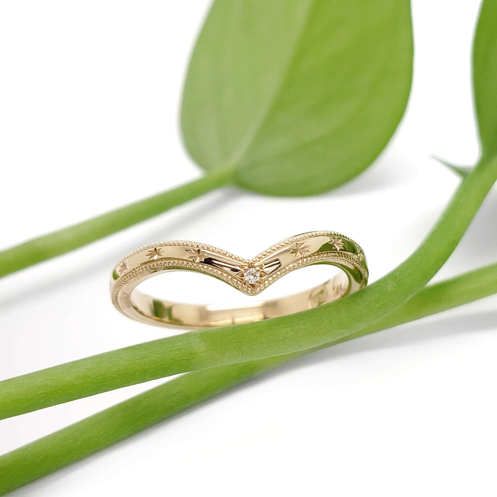Handcrafted 14kt yellow gold engraved chevron ring with diamond, styled with green leaves