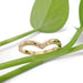 Handcrafted 14kt yellow gold engraved chevron ring with diamond, styled with green leaves