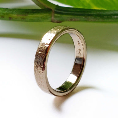 Handcrafted 14kt yellow gold textured wedding ring shown upright with hallmark visible