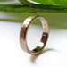 Handcrafted 14kt yellow gold textured wedding ring shown upright with hallmark visible