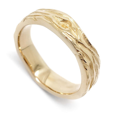 Handcrafted 14kt yellow gold wedding ring with woodgrain texture, angled view
