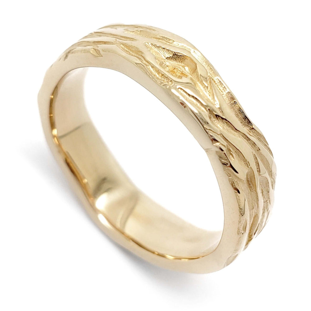 Handcrafted 14kt yellow gold wedding ring with woodgrain texture, angled view