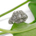 Handcrafted 19kt white gold diamond ring with vintage-inspired engraving on a green leaf