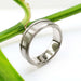 Handcrafted brushed 14kt white gold ring with carved wave detail, shown on plant stem