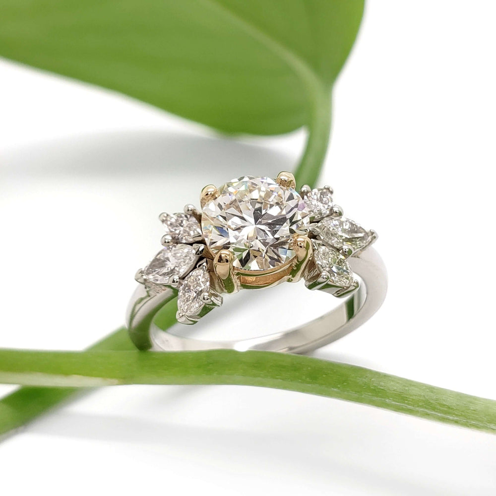 Handcrafted two-tone gold diamond engagement ring with lab diamond, shown with green leaf