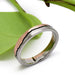 Handcrafted white and rose gold mountain range ring on green leaf background