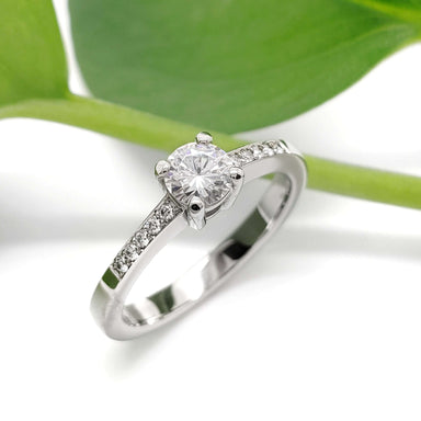 Handcrafted white gold engagement ring with moissanite and lab diamonds, leaf background