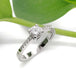 Handcrafted white gold engagement ring with moissanite and lab diamonds, leaf background