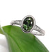 Handcrafted white gold engagement ring with oval green Australian sapphire and diamond accents on a leaf