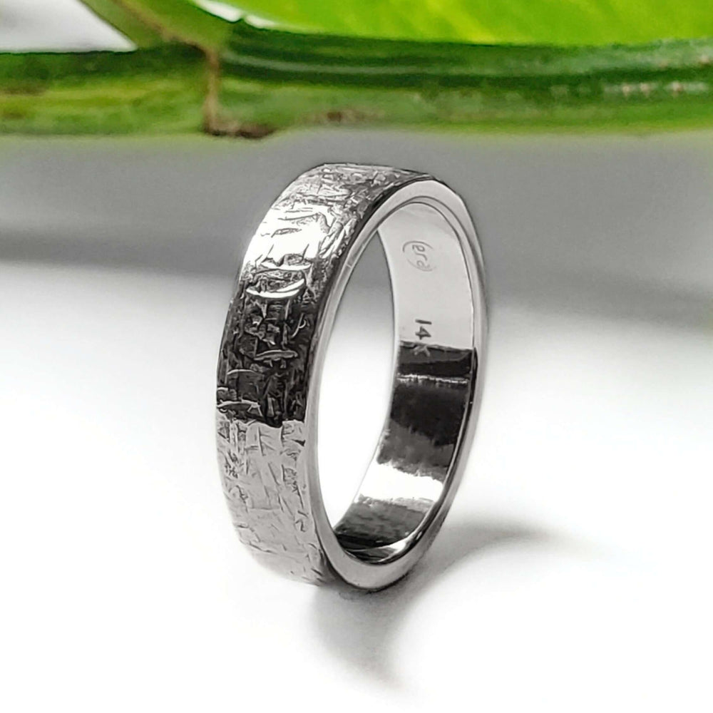 Handcrafted white gold wedding ring with textured surface, side view