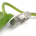 Handcrafted white gold wedding band with brushed finish and engraved edges beside a green leaf