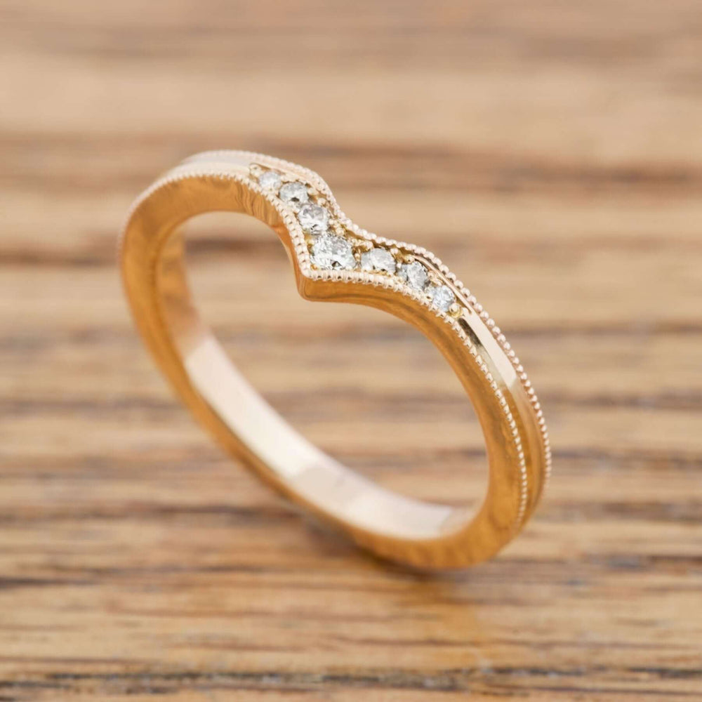 Handcrafted 14k yellow gold chevron band with Canadian diamonds on wood background