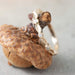 Handcrafted yellow gold diamond leaf ring resting on an acorn