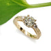 Handcrafted yellow gold engagement ring with old European diamond, leaf engraving, and accent stones