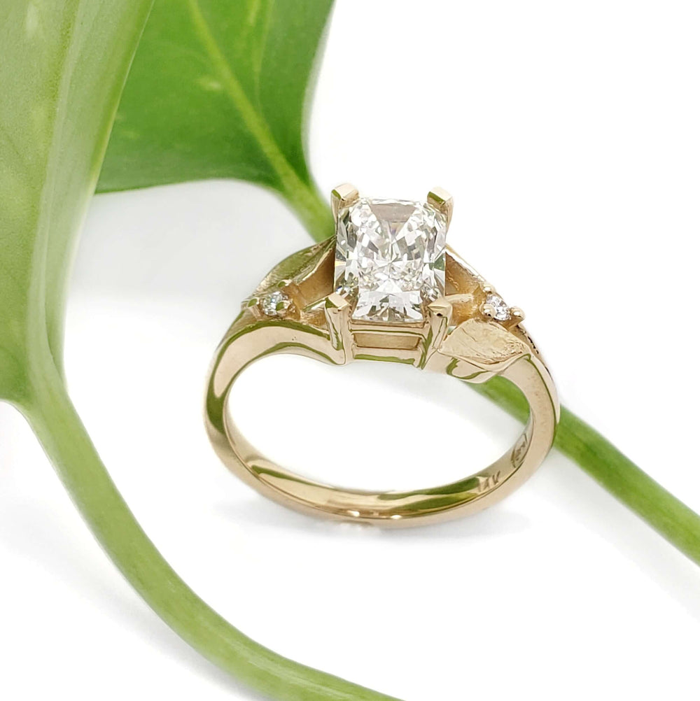 Handcrafted yellow gold lab diamond ring with leaf motif, shown with green leaf