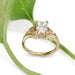 Handcrafted yellow gold lab diamond ring with leaf motif, shown with green leaf