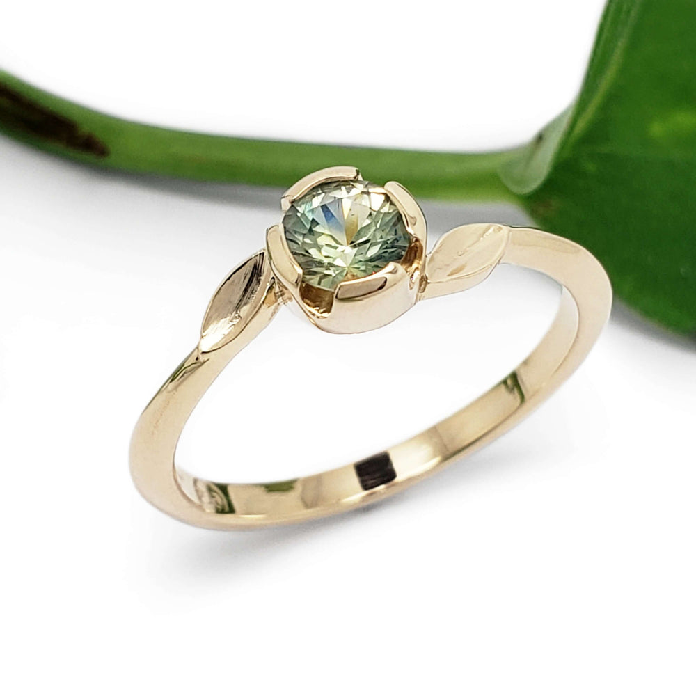 Handcrafted yellow gold ring with green Montana sapphire and sculpted leaf accents
