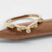 Handcrafted yellow gold wedding band with diamonds on a wood background
