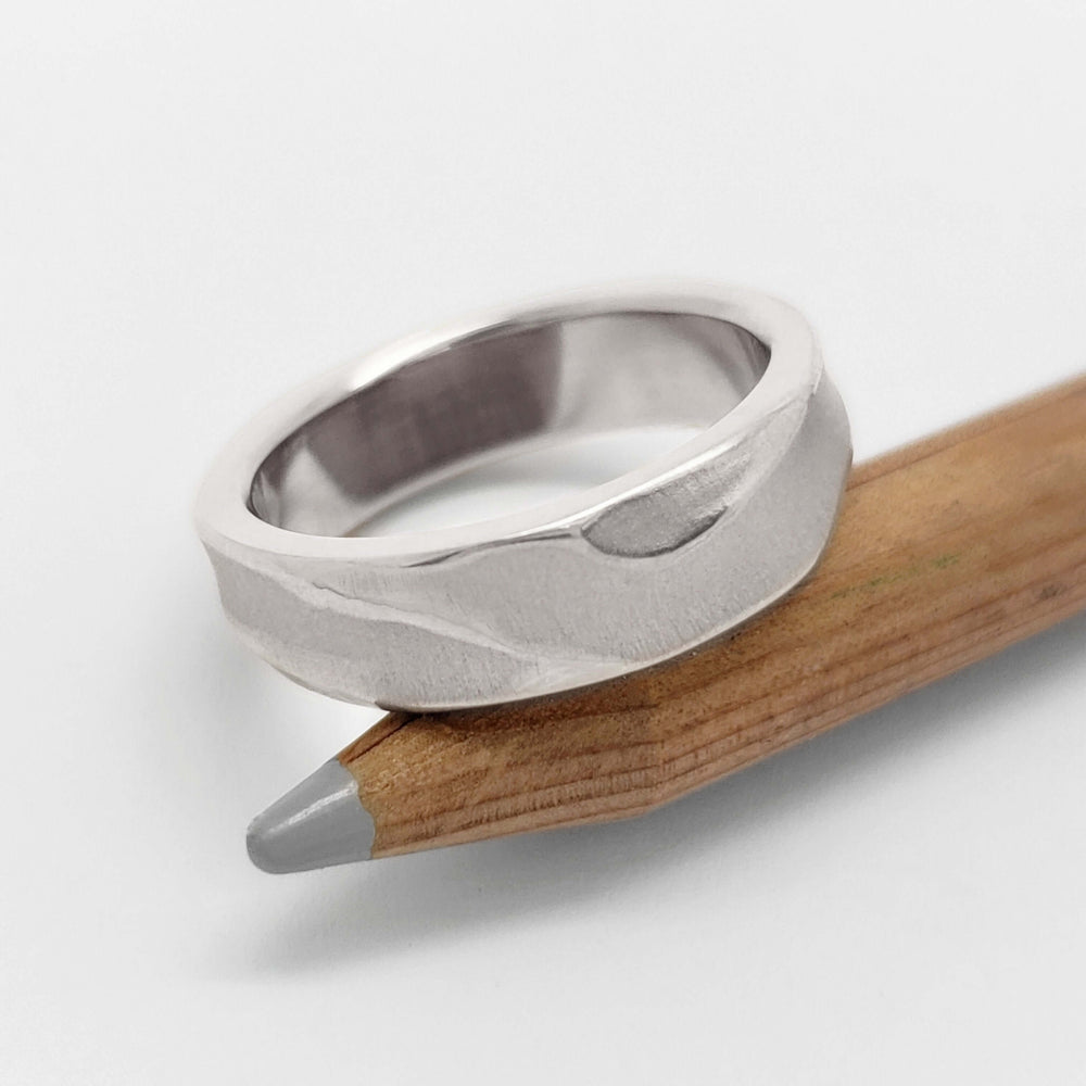 Handmade 14kt white gold topography ring displayed on a pencil