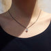 Heart-shaped lab diamond pendant in white gold on black chain, worn on a model's neck