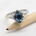 Hexagon blue Montana sapphire and triangle diamond ring in white gold, shown on a pencil