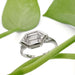 Hexagon lab diamond engagement ring in white gold displayed with green leaves