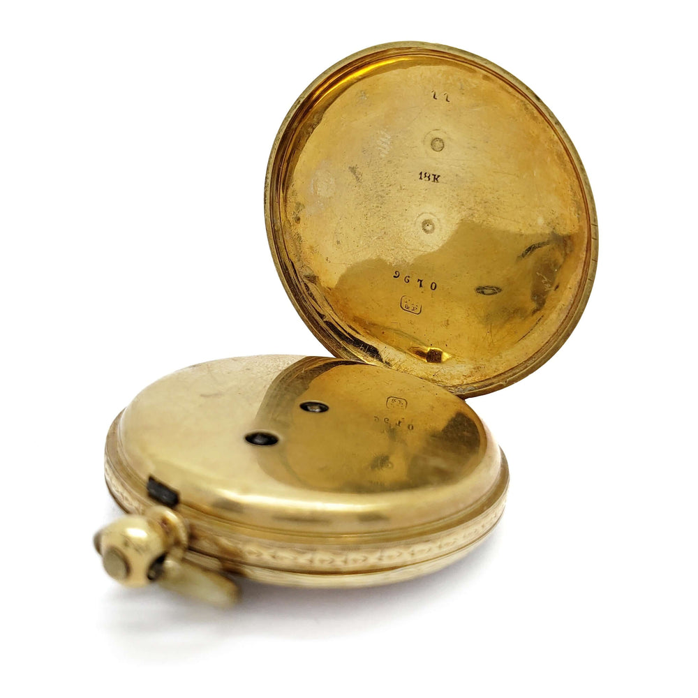 Interior of antique 18kt yellow gold pocket watch showing hallmarks and mechanism