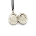 Open vintage oval sterling silver locket showing interior photo slots