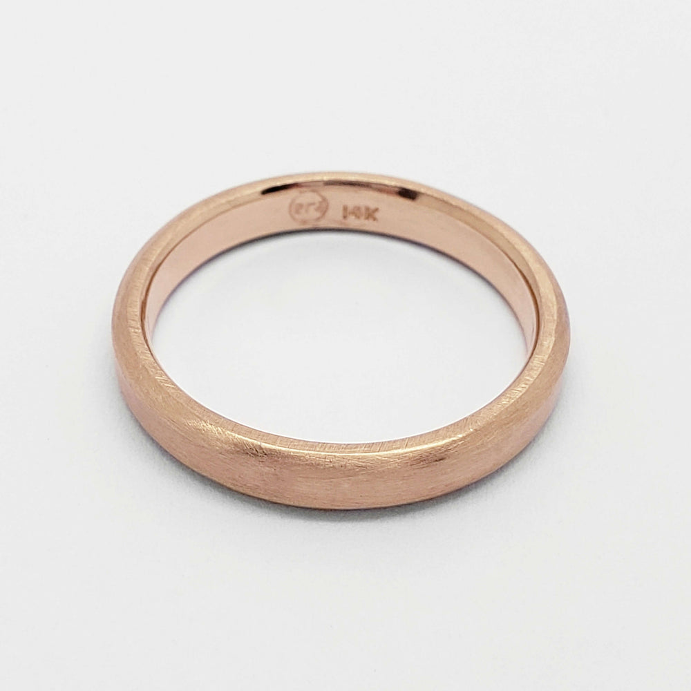 Interior view of 14k rose gold flat wedding ring showing hallmark and brushed finish