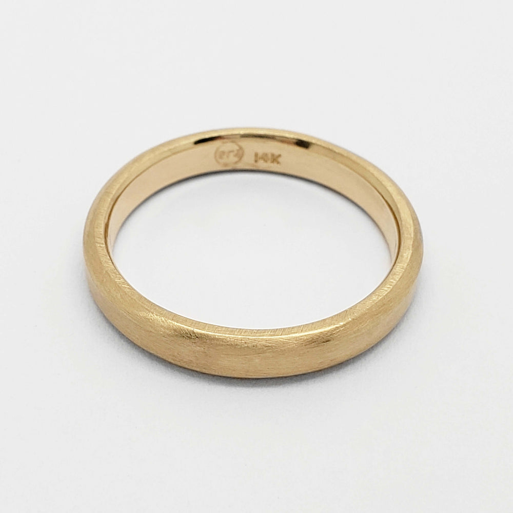 Interior view of 14k yellow gold wedding ring showing hallmark and brushed finish
